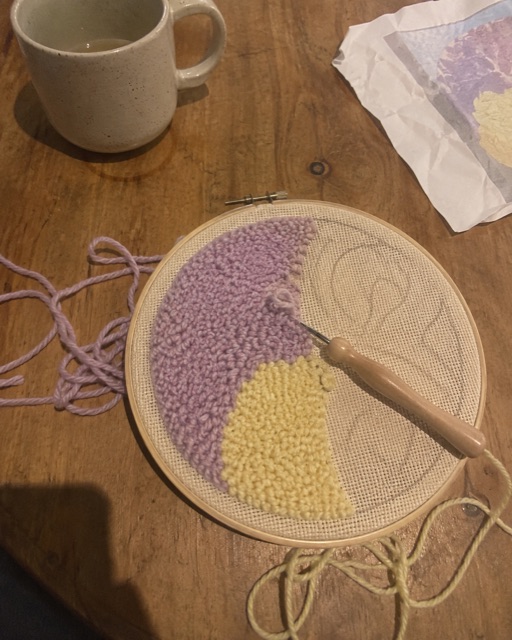 Punch needle work in progress in a hoop